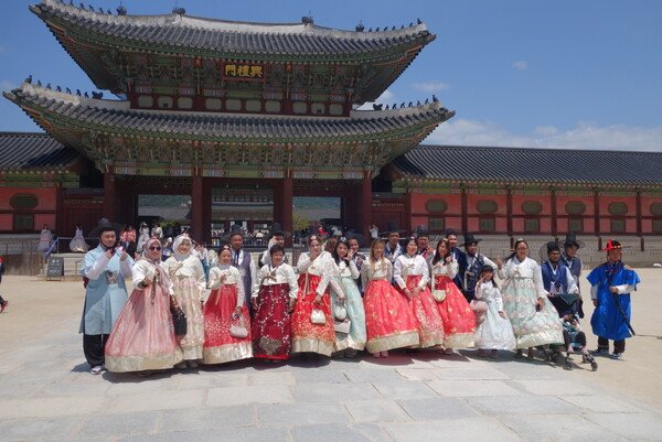 Foreign tourists wearing traditional Korean hanbok at Gyeongbokgung Palace in Seoul, South Korea