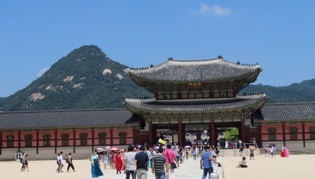 Gwanghwamun Gate at Gyeongbokgung Palace in Seoul with tourists walking through the historic palace entrance