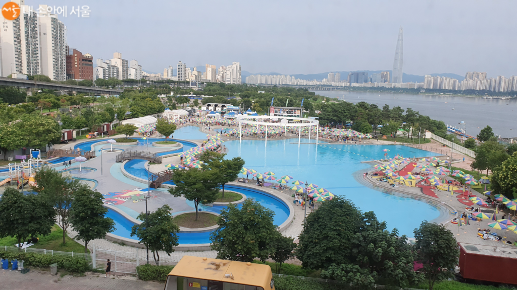 Ttukseom Hangang Park swimming pool in Seoul with visitors enjoying the riverside pool and views of the Han River