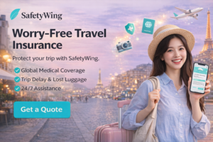 Horizontal SafetyWing travel insurance banner showing a traveler with luggage and smartphone, promoting global medical coverage, trip support, and 24/7 assistance.