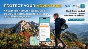 A travel insurance promotion banner featuring a hiker with a backpack on a rocky Korean mountain peak. In the foreground, a smartphone displays the SafetyWing app interface showing medical insurance coverage details. The text emphasizes protecting your adventure with travel medical insurance for slips, injuries, and unforeseen events while hiking in South Korea