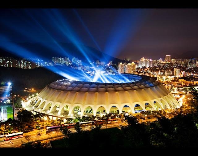 Busan Asiad Main Stadium in South Korea, the concert venue for the BTS Busan Concert Travel Guide 2026, showing the stadium exterior and large-scale event atmosphere